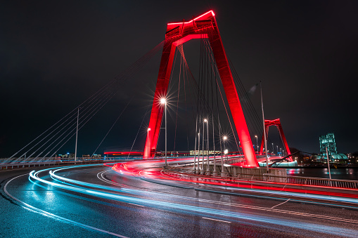 Rotterdam, Willemsbrug at night. Beautiful red bridge crossing of the river meuse in the Netherlands. Light trails from traffic.