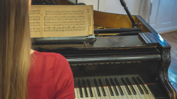 istock Beautiful young woman plays piano 1195459859