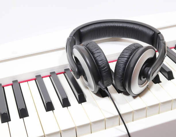istock Black headphones on piano keyboard 1195460085