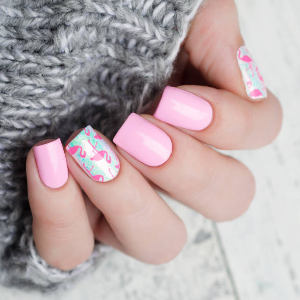 istock Pink manicure with pink flamingo pattern with gray sweater 1195461943