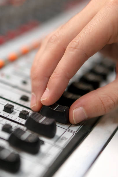 istock Male hand on control Fader on console. Sound recording studio mixing desk with engineer or music producer. 1195461971