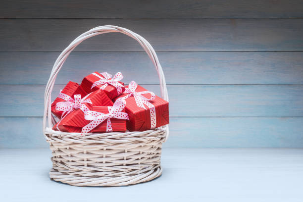 istock Alike red gift boxes in basket over wooden background with copy space 1195462949