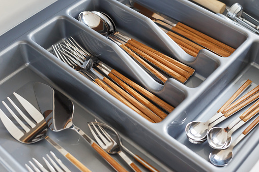 Stylish cutlery with wood-effect handles in organizer. Scandinavian style, hygge