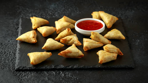 istock Fresh Indian Samosa with dipping sweet chili sauce on rustic stone board 1195464349