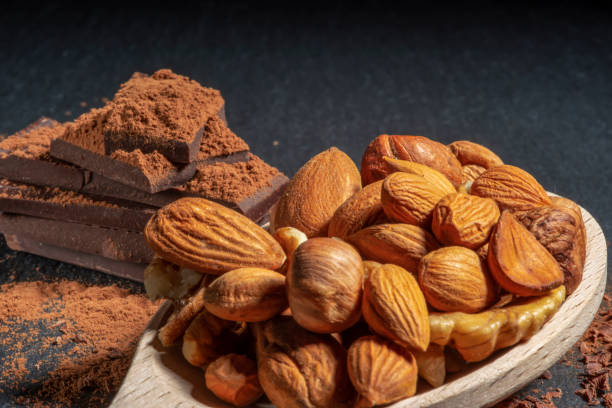 istock Almond and hazelnuts in a wooden spoon on a dark background 1195468172