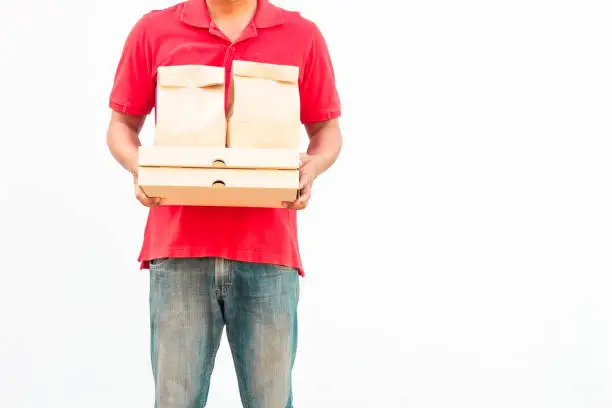 Photo of Holding various take-out food containers, pizza box, in holder and paper bag, close-up. Light grey background, place to insert your text. Delivery man.
