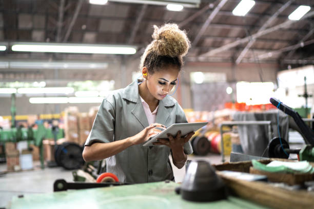 istock Young woman using digital tablet in a factory 1195472430