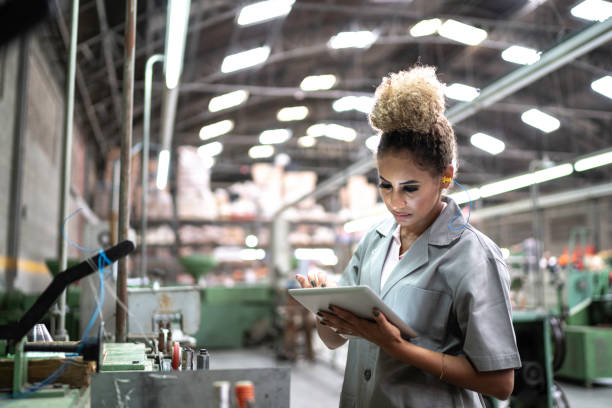 istock Young woman using digital tablet in a factory 1195472491