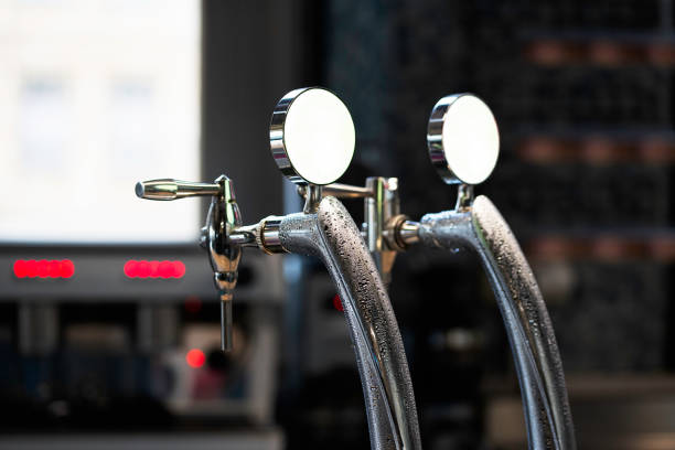 Close-up of shiny beer tap over unfocused background at brewery bar. stock photo