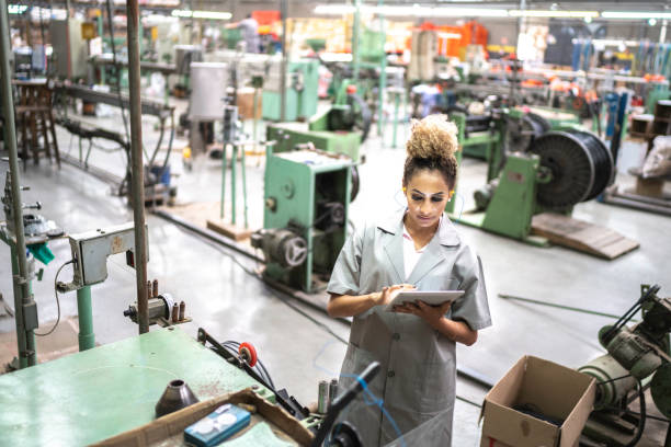 istock Young woman using digital tablet in a factory 1195478233