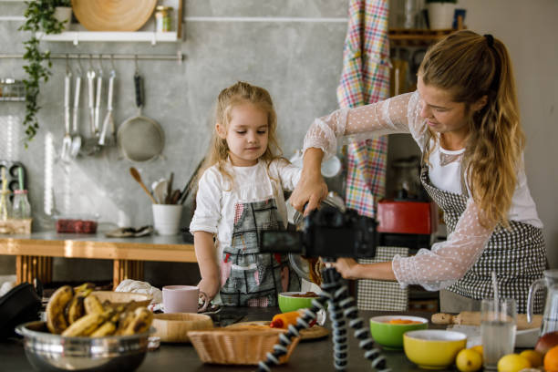 istock Mother and daughter preparing a dessert on camera 1195481594