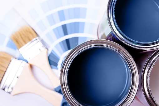 Pinceles de pintura colocados en la parte superior de lata llena de pintura azul. Color azul clásico del año 2020. photo