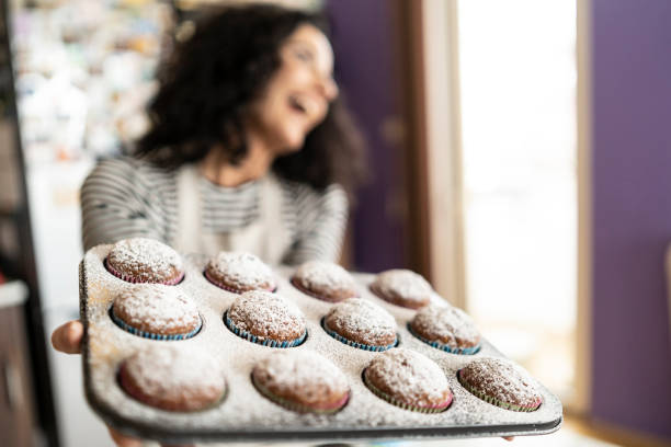 istock Smiling mother having fun with homemade muffins 1195482789
