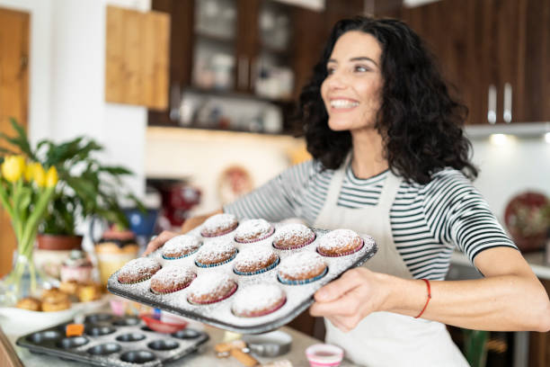 istock Smiling mother having fun with homemade muffins 1195482790
