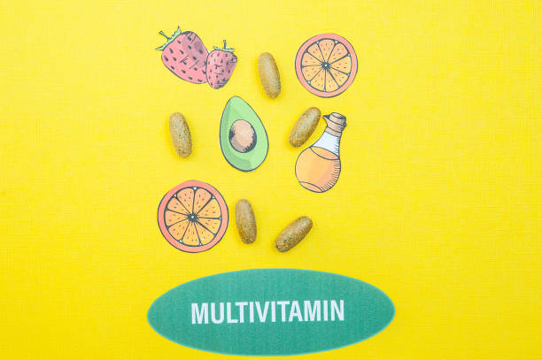 concept multivitaminici e integratori, una fontana delle loro capsule e prodotti utili su sfondo giallo - bottle capsule cod routine foto e immagini stock