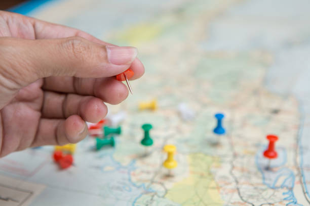 istock Selective focus of hand holding a pin on map background 1195488900