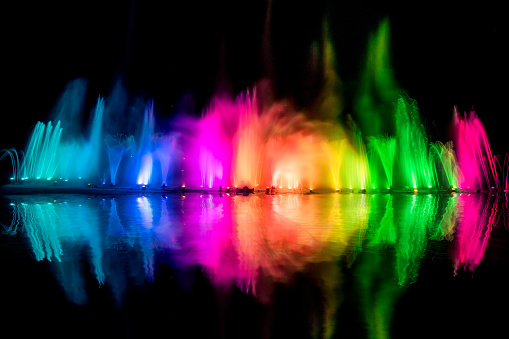 The colorful water fountain dancing in celebration festival refection color on water with dark night sky background