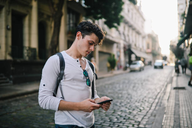 istock Young man using smartphone in the street 1195495240