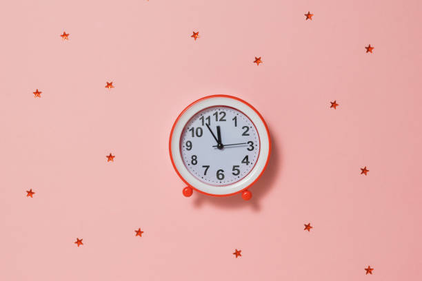 istock Red alarm clock with red stars on red background. 1195495464