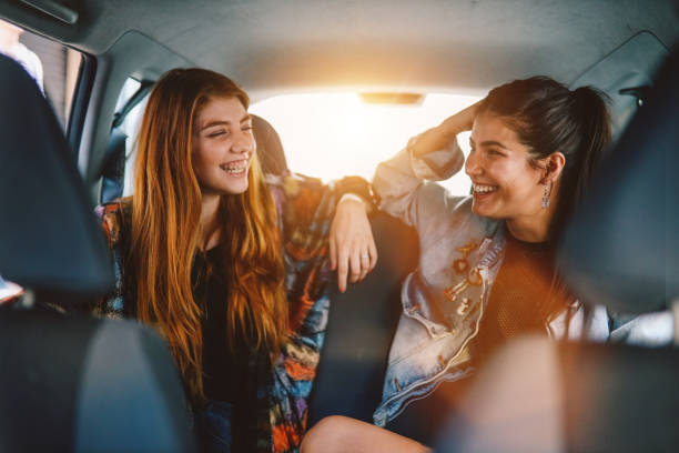 two girls in the backseat of a ride share in buenos aires - back seat imagens e fotografias de stock