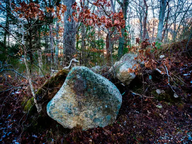 Photo of Old mossy boulder balanced on hillside