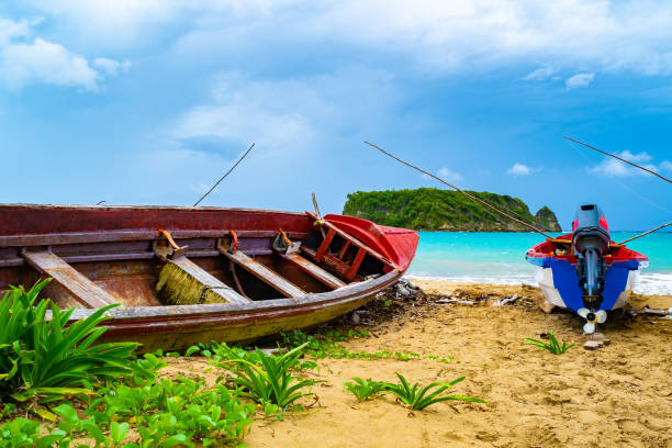 colorful old wooden fishing boats docked by water on a beautiful beach coast. white sand sea shore landscape on tropical caribbean island. - cabarita beach imagens e fotografias de stock