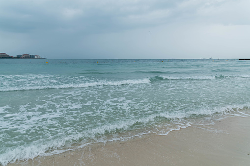 Dramatic Cloudy Sky and Thunderstorm, Sea Waves at Jumeirah Beach in Dubai, UAE.