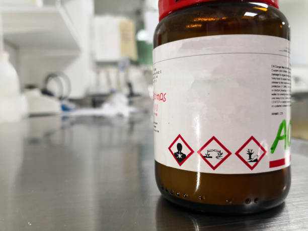 Corrosive, toxic and polluting chemical inside a laboratory glass amber bottle Concept of a dangerous chemical substance, corrosive, toxic and polluting for the environment, inside a laboratory glass amber bottle hazardous waste symbol stock pictures, royalty-free photos & images