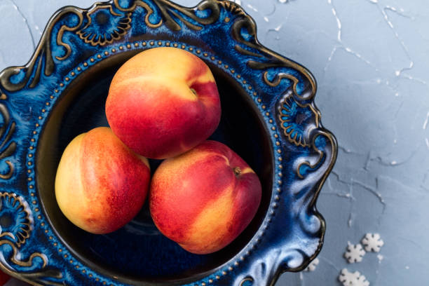 istock Ripe nectarines in a vintage blue plate, smooth peaches on the table 1195510498