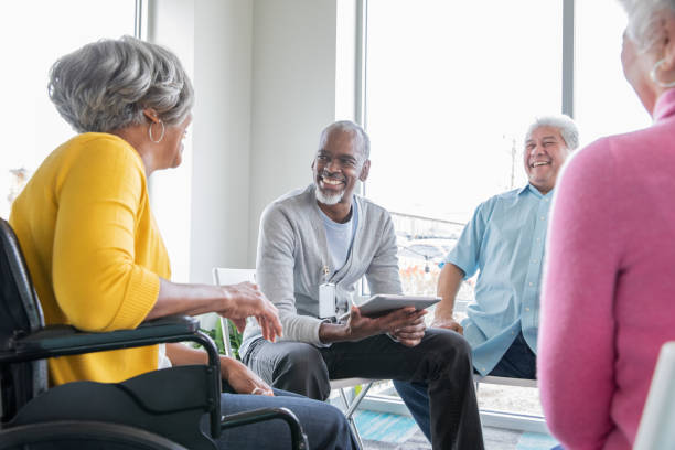 istock Group of seniors smiling and talking at group therapy sessions 1195510530