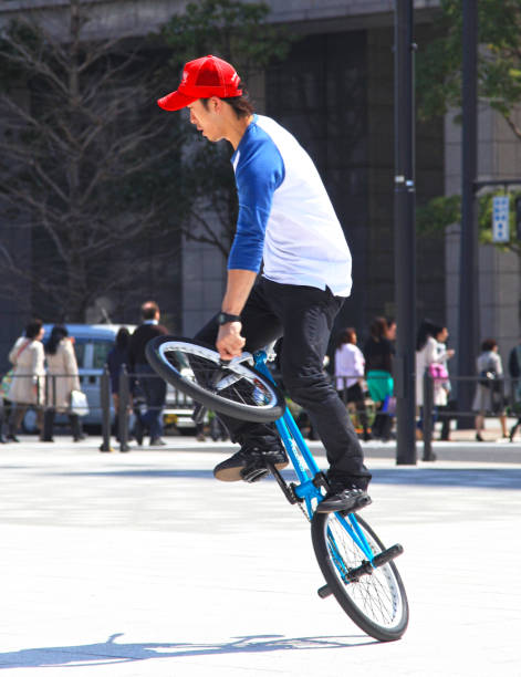 Freestyle cyclist practicing street BMX in backlight at sunset