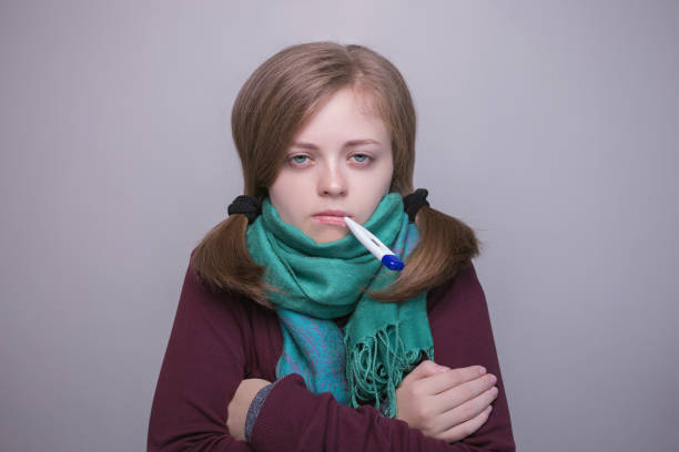 joven mujer caucásica con termómetro se ve enferma, fiebre, frío - sniffles fotografías e imágenes de stock