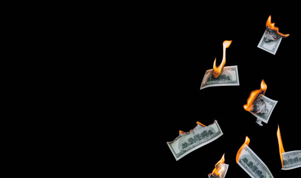 Several 100 dollar bills, falling down, burn on a black background. The concept of bankruptcy, depreciation, devaluation, wastefulness and waste of money. Copy space, isolated. stock photo