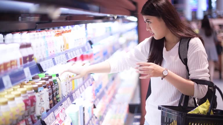 Asian woman shopping on dairy product in supermarket