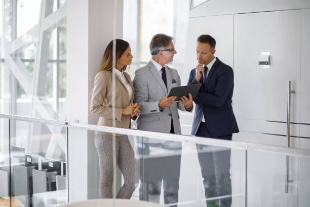 istock Group of mixed aged business people collaborating over digital tablet 1195529147
