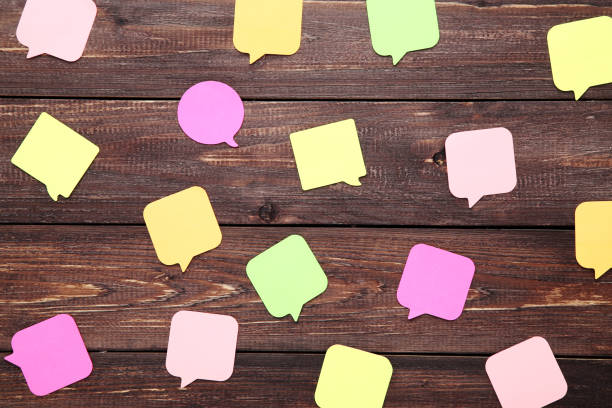 istock Paper speech bubbles on brown wooden table 1195529314