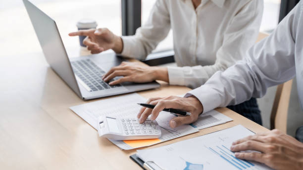 istock Financial analyst using laptop calculating numbers in office. 1195529315
