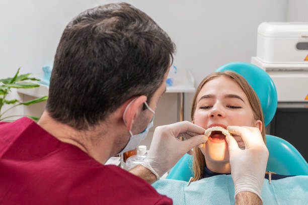 istock dentist puts teeth on his patient 1195530060