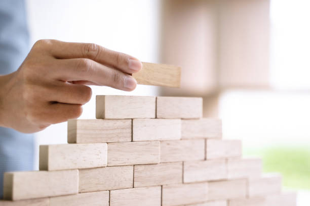 istock hand building up the tower, Business risk and strategy concept. 1195532414