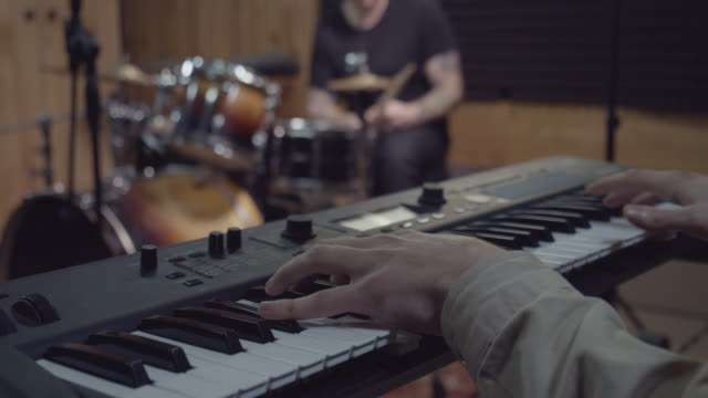 Band musician playing song on piano in studio, composing music hit for concert