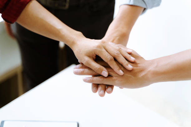 istock People put hands together in meeting room. 1195538658
