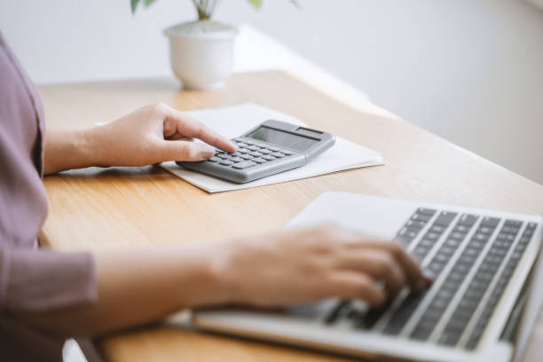 istock Close up hand of woman using calculator. 1195538710