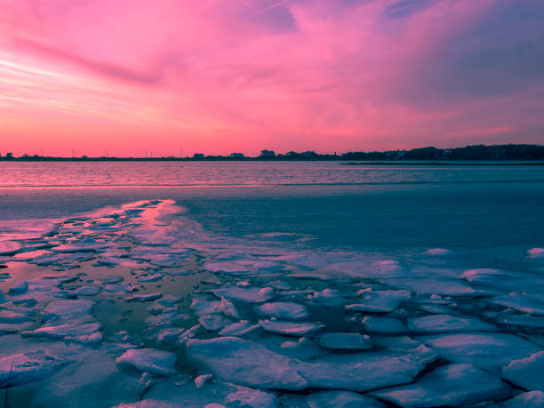 Sunset bay view with broken pieces ice floating in sea water