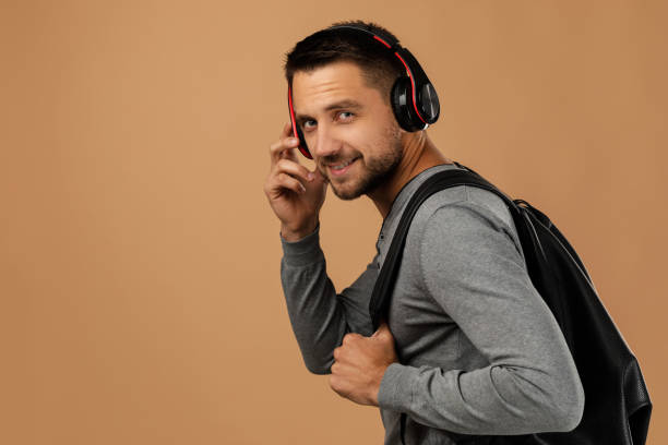 istock handsome young man with headphones and backpack 1195543586