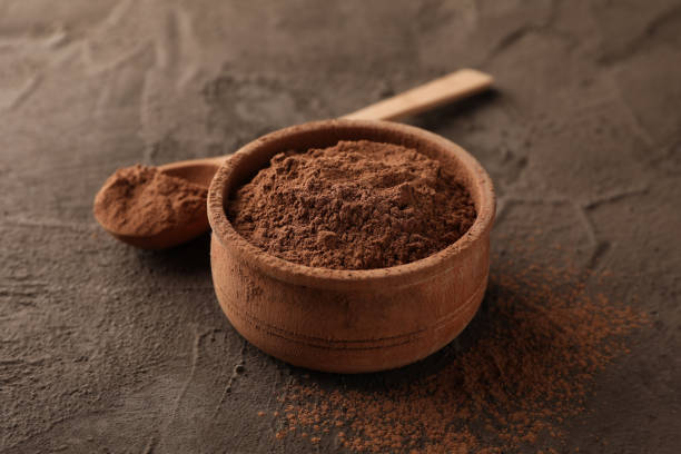 istock Bowl with cocoa powder and spoon on brown background, closeup 1195548993