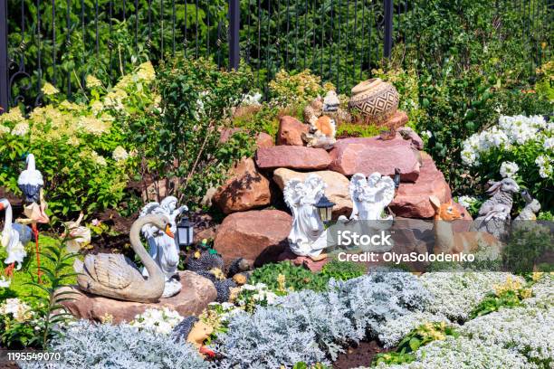 Garden Statues Of Angels And Animals On Flowerbed Stock Photo - Download Image Now - Yard - Grounds, Figurine, Fairy