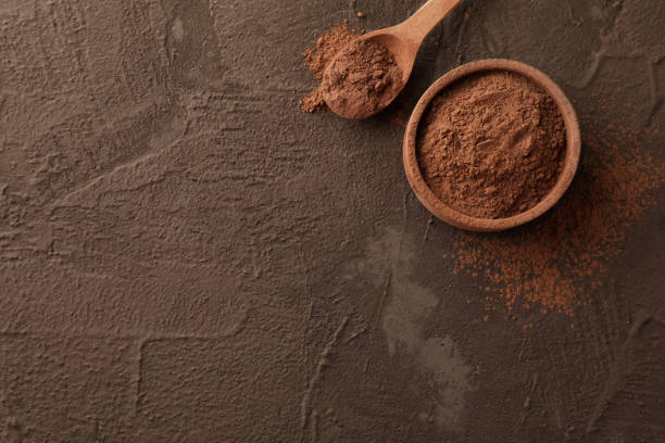istock Bowl with cocoa powder and spoon on brown background, space for text 1195549263