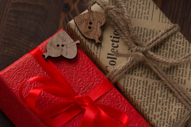 istock Valentines day card background with red present gift box on wooden table 1195549459