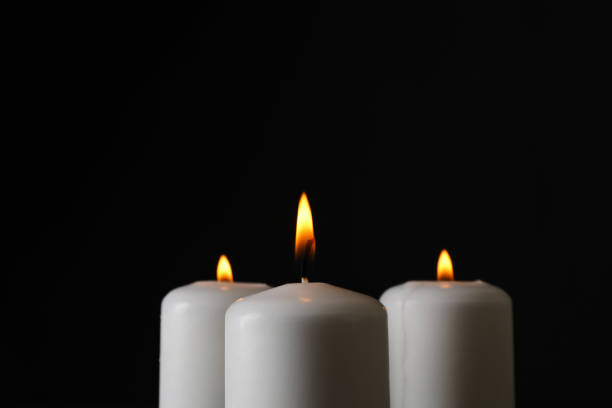 istock Glowing candles on black background, space for text 1195555037