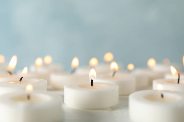 grupo de velas encendidas contra fondo azul, de cerca - symbol religion spirituality image fotografías e imágenes de stock